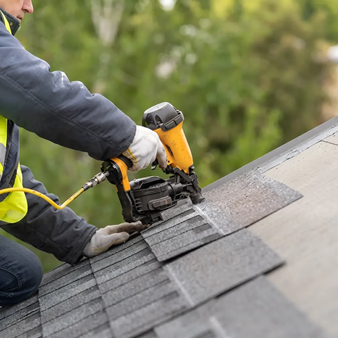 Installer fitting shingles on a residential roof