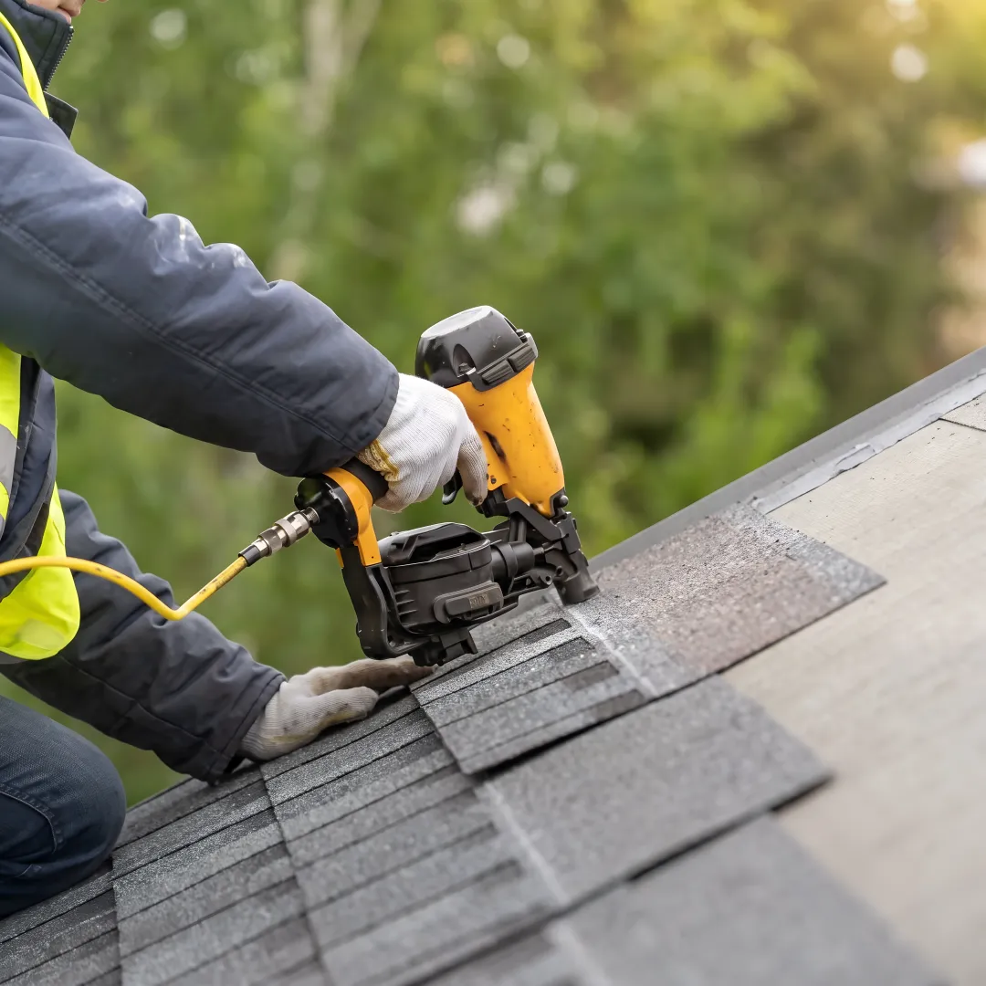 Roofer installing reflective shingles on a home