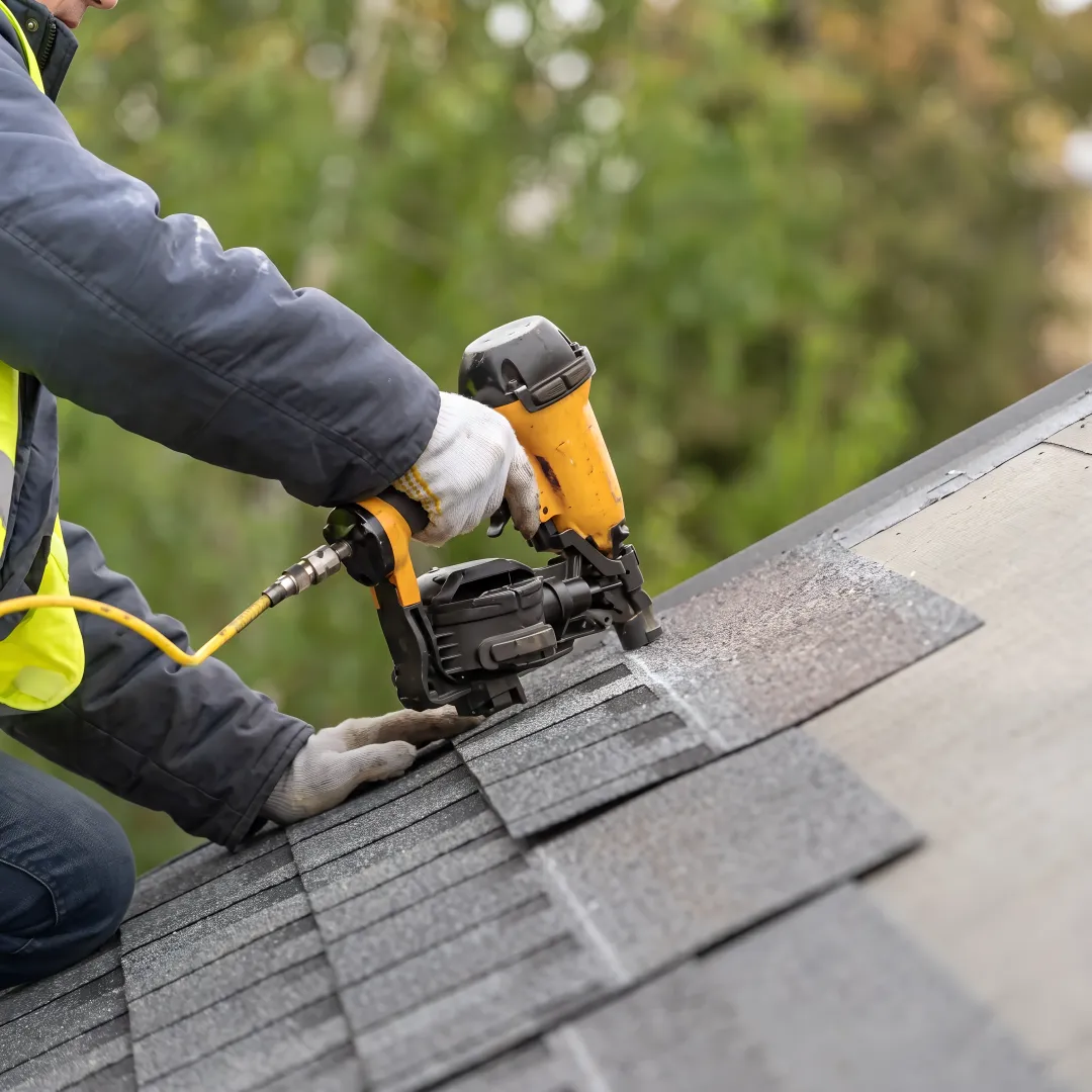 Roofing crew installing shingles on a home