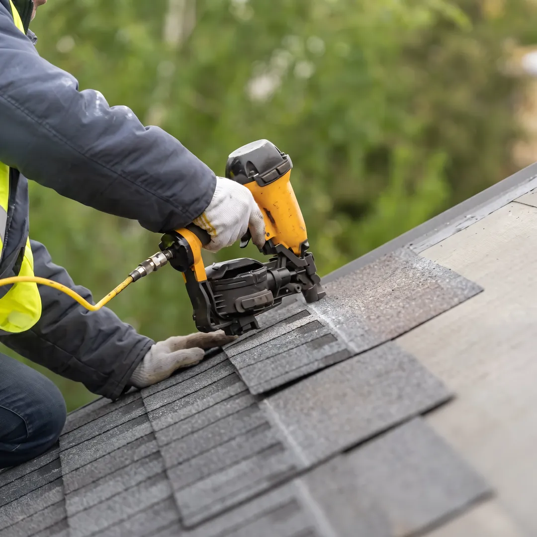 Roofer installing asphalt shingles