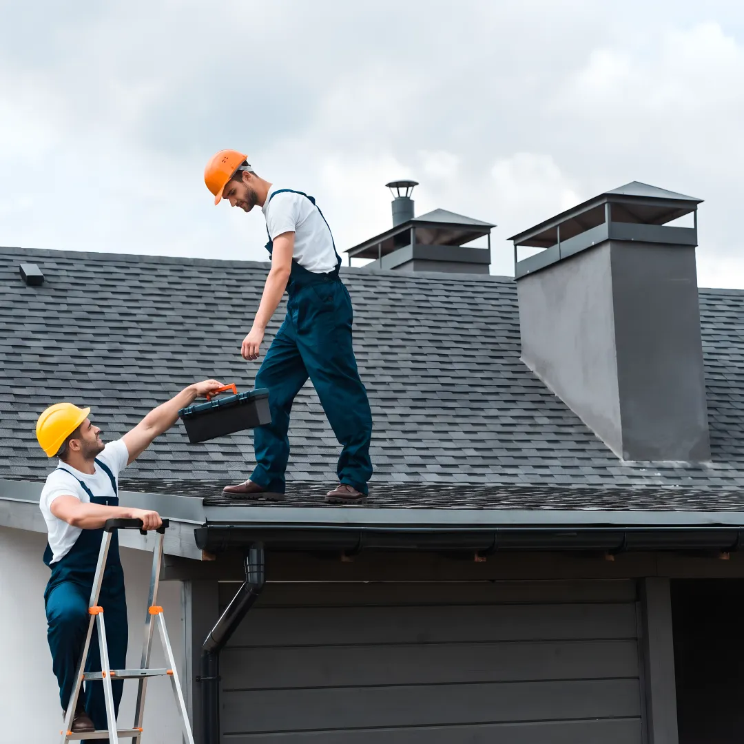 Roofer inspecting shingles on a residential roof