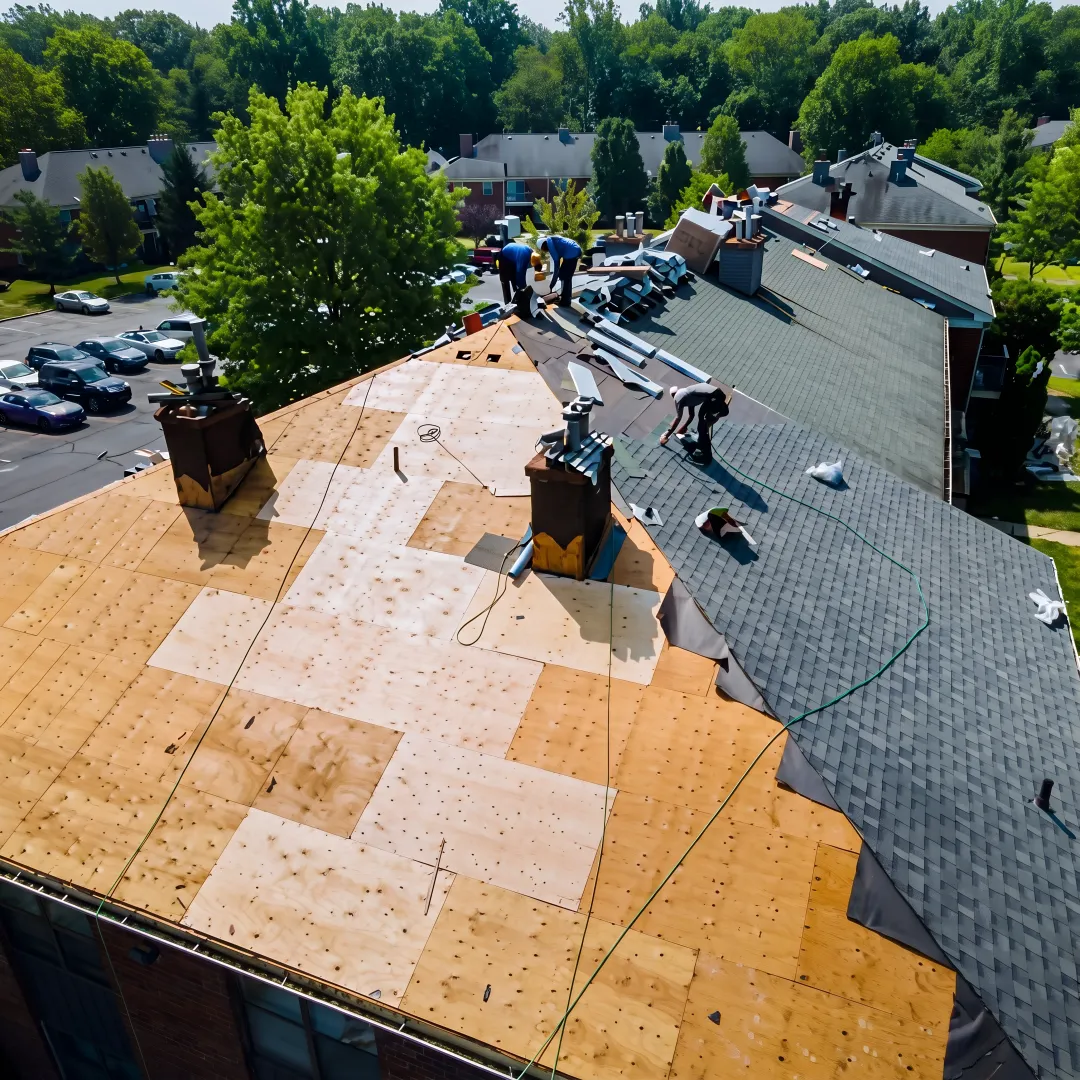 Roofing crew repairing a multi-family property roof