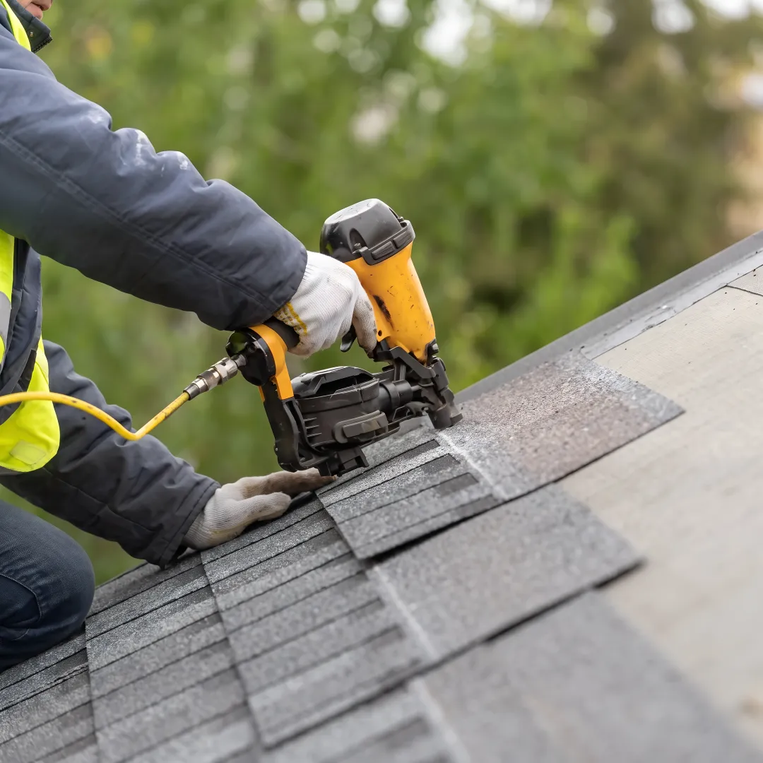 Roofer completing a shingle repair