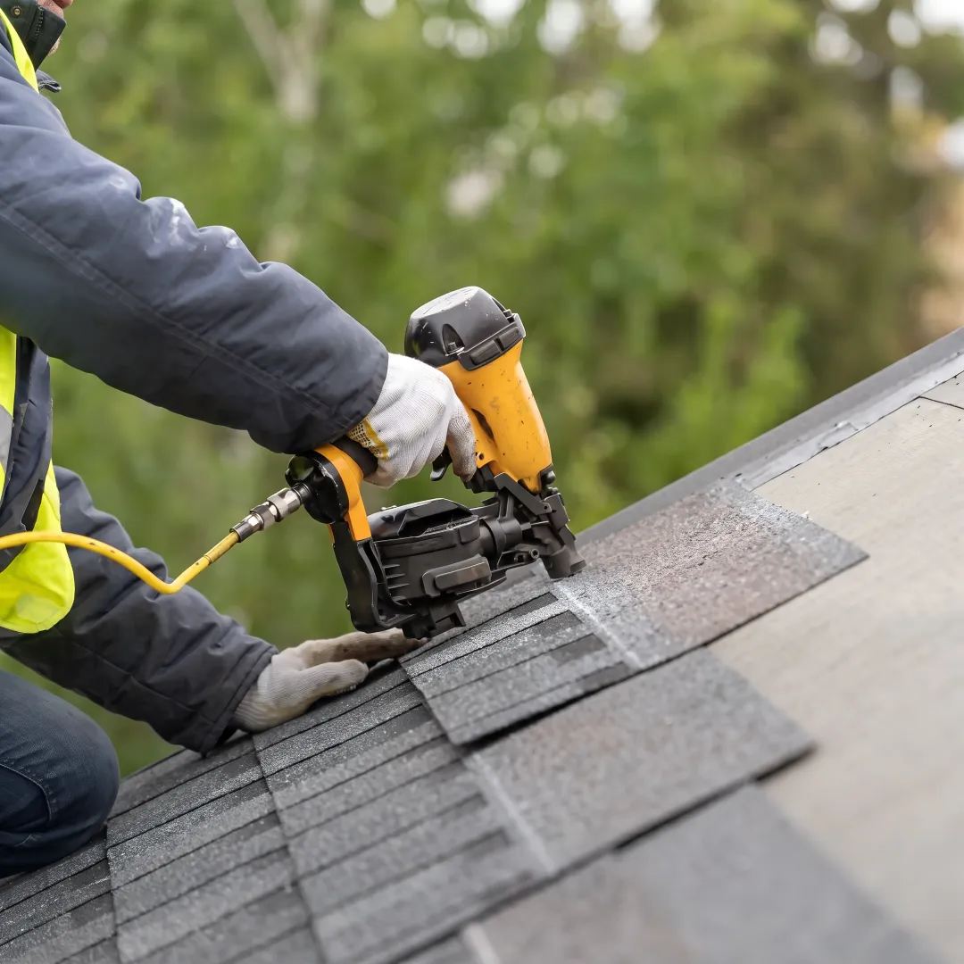 Roofing technician repairing damaged shingles