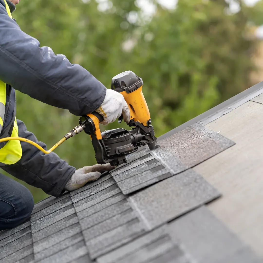Roofing professional installing shingles on a home