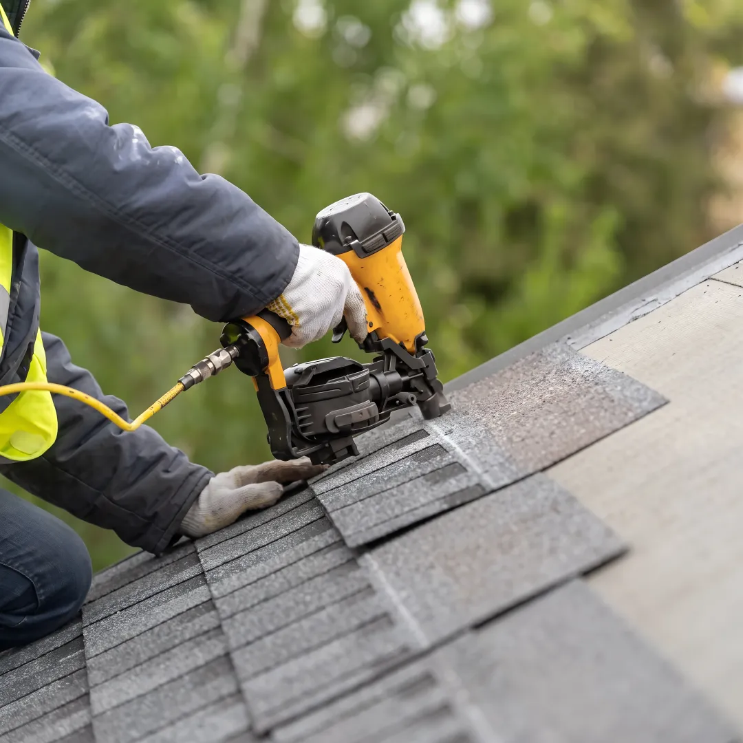 Installer inspecting reflective shingles on a Florida home