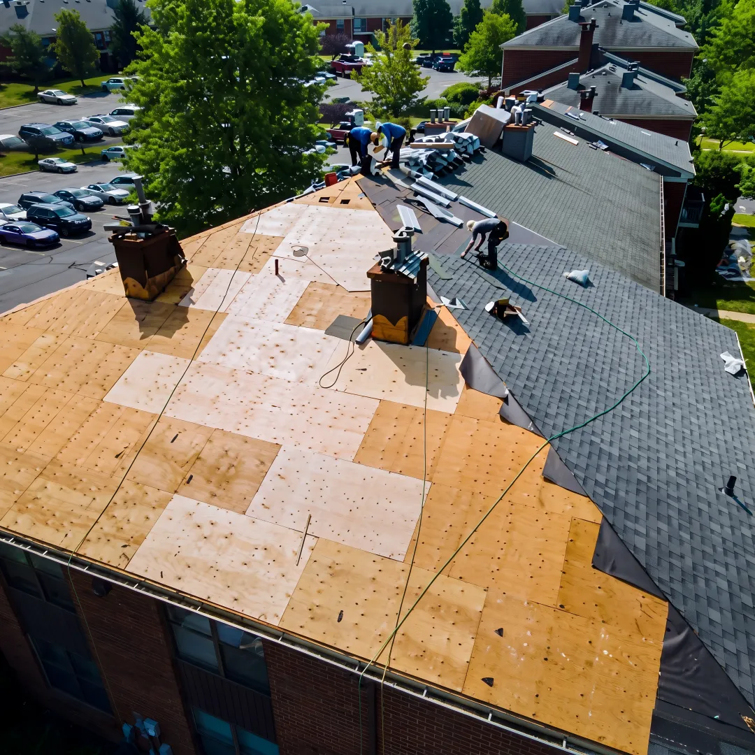 Roofer inspecting exposed roof deck after removal
