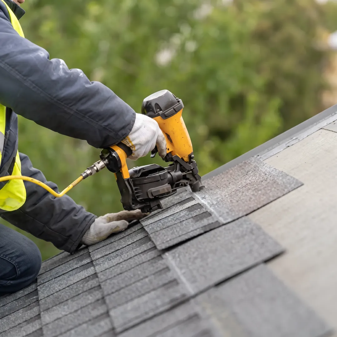 Roofer installing reflective shingles on a home