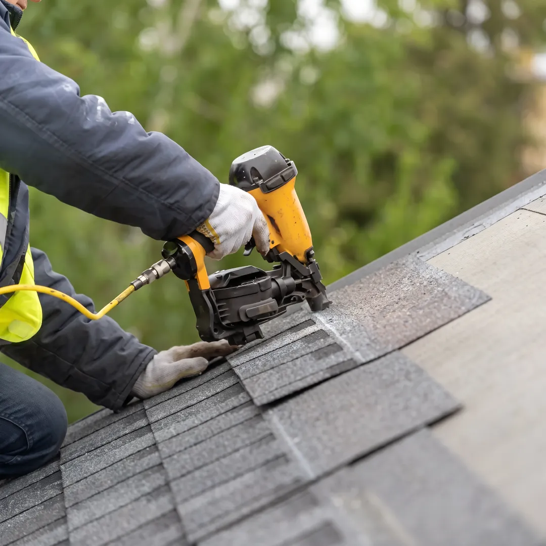 Installer fitting reflective roofing shingles
