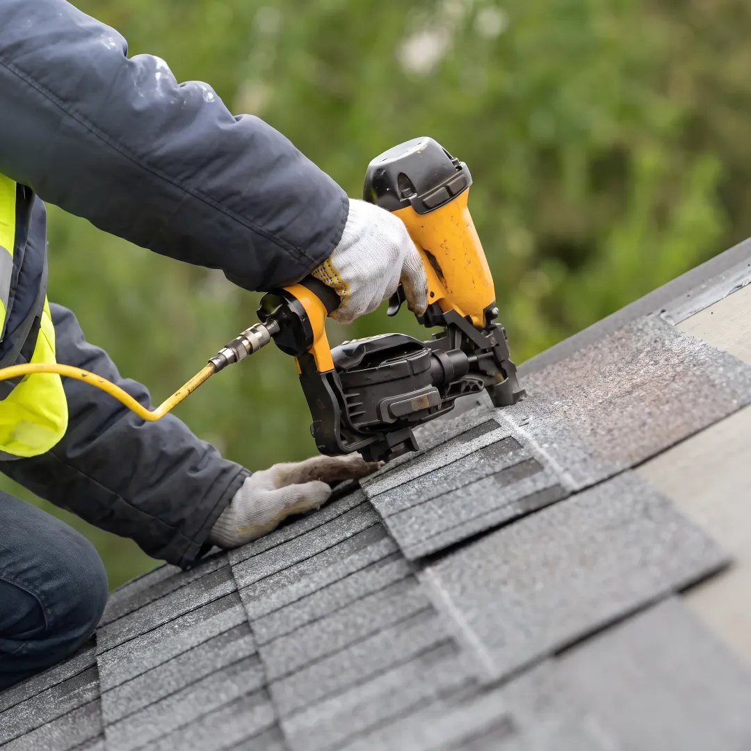 Roofer installing reflective shingles