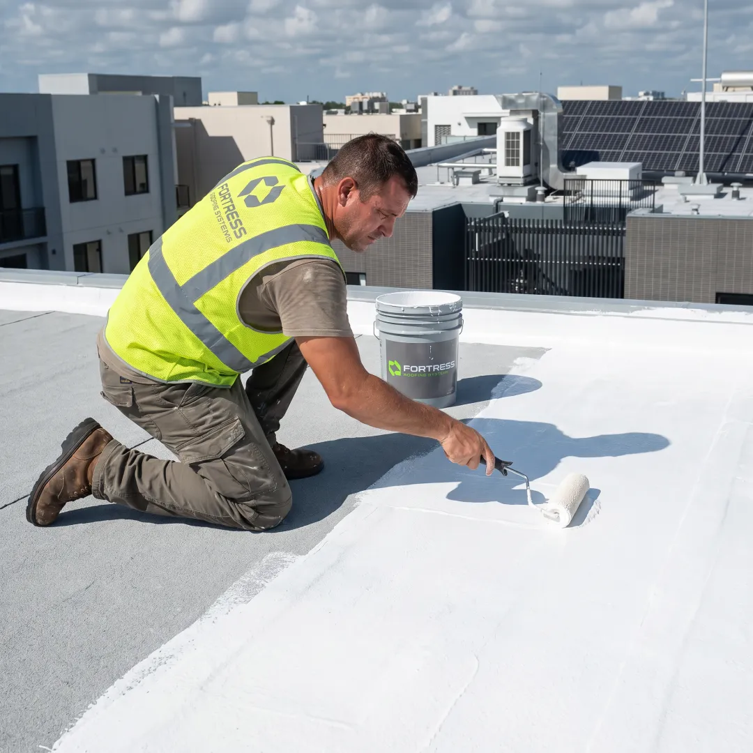 Technician applying waterproof roof coating