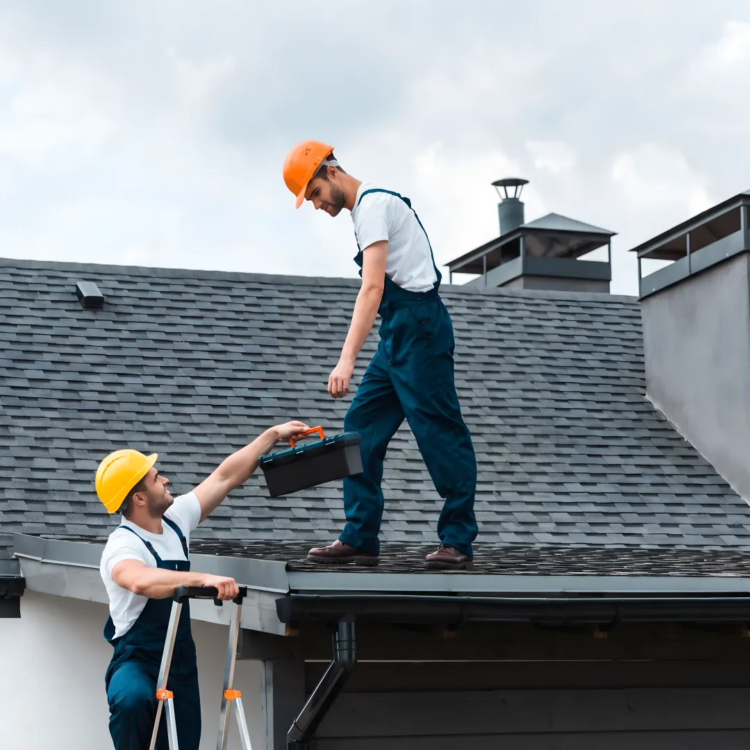 Roofers installing shingles on a home