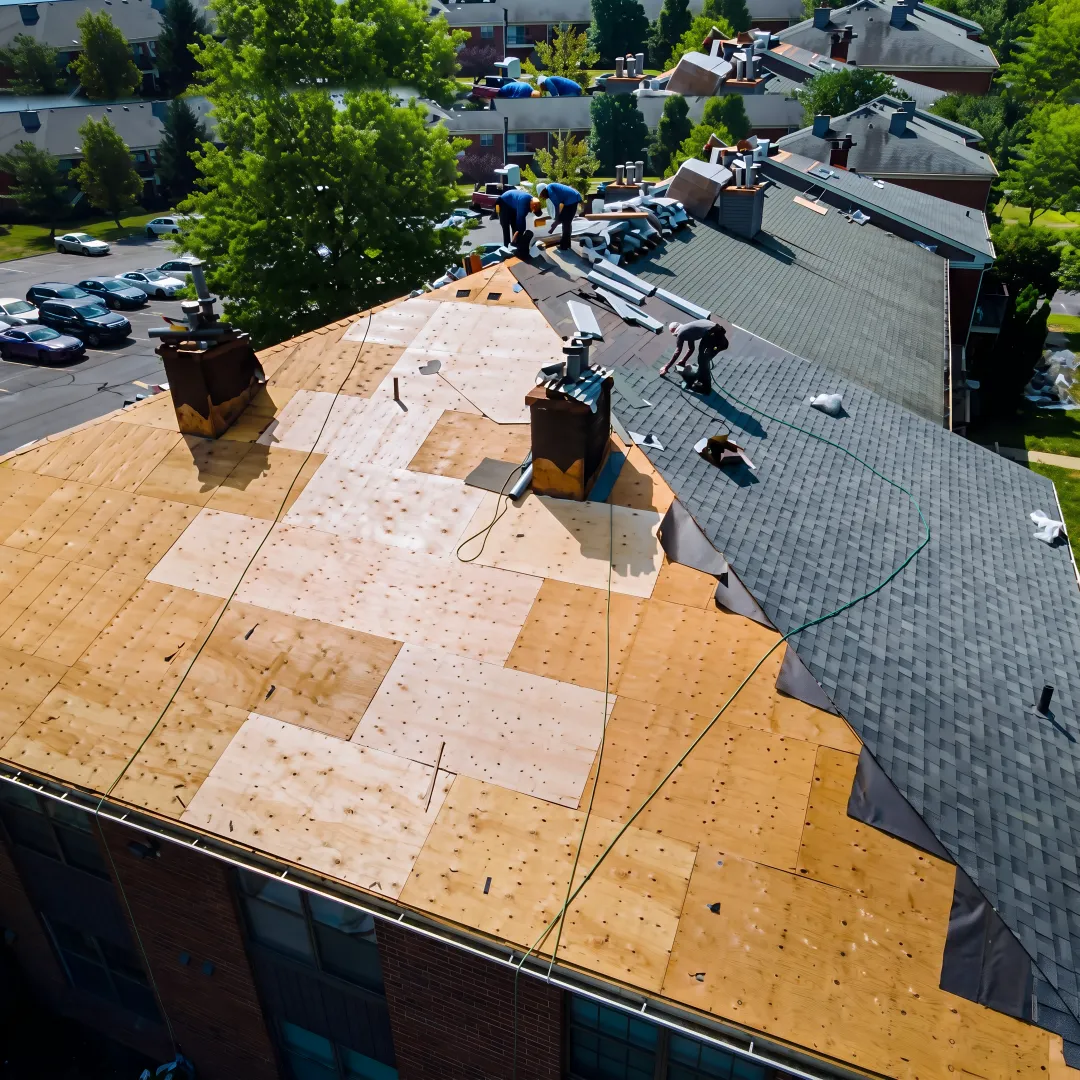Contractor examining roof shingles and flashing