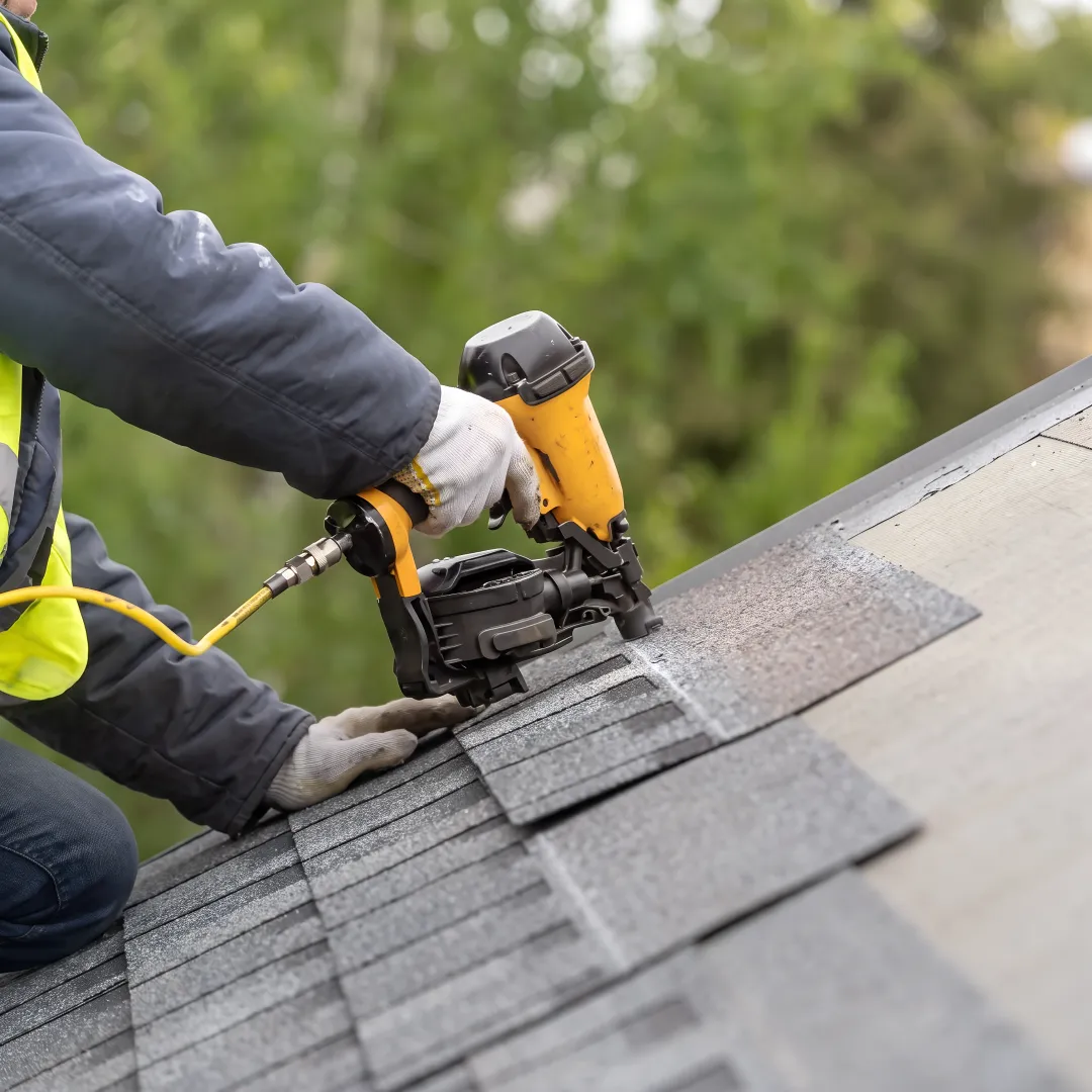 Roofer installing reflective shingles