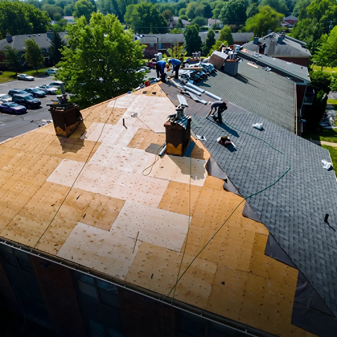 Roofers installing a metal roofing panel