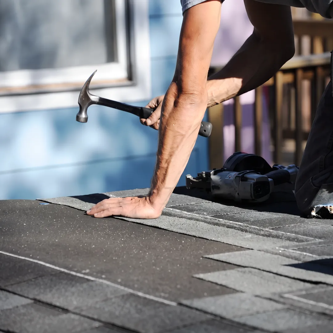 Roofing technician inspecting a repaired roof section