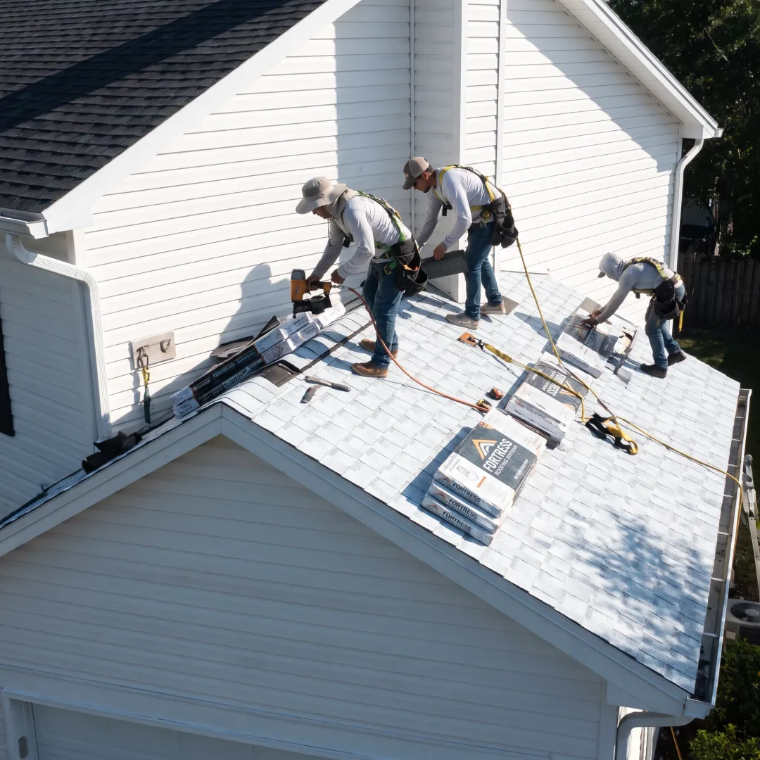 Roofers installing reflective shingles on a home