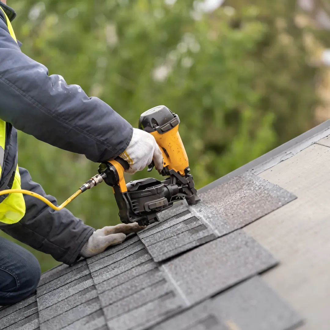Roofer installing shingles on a home