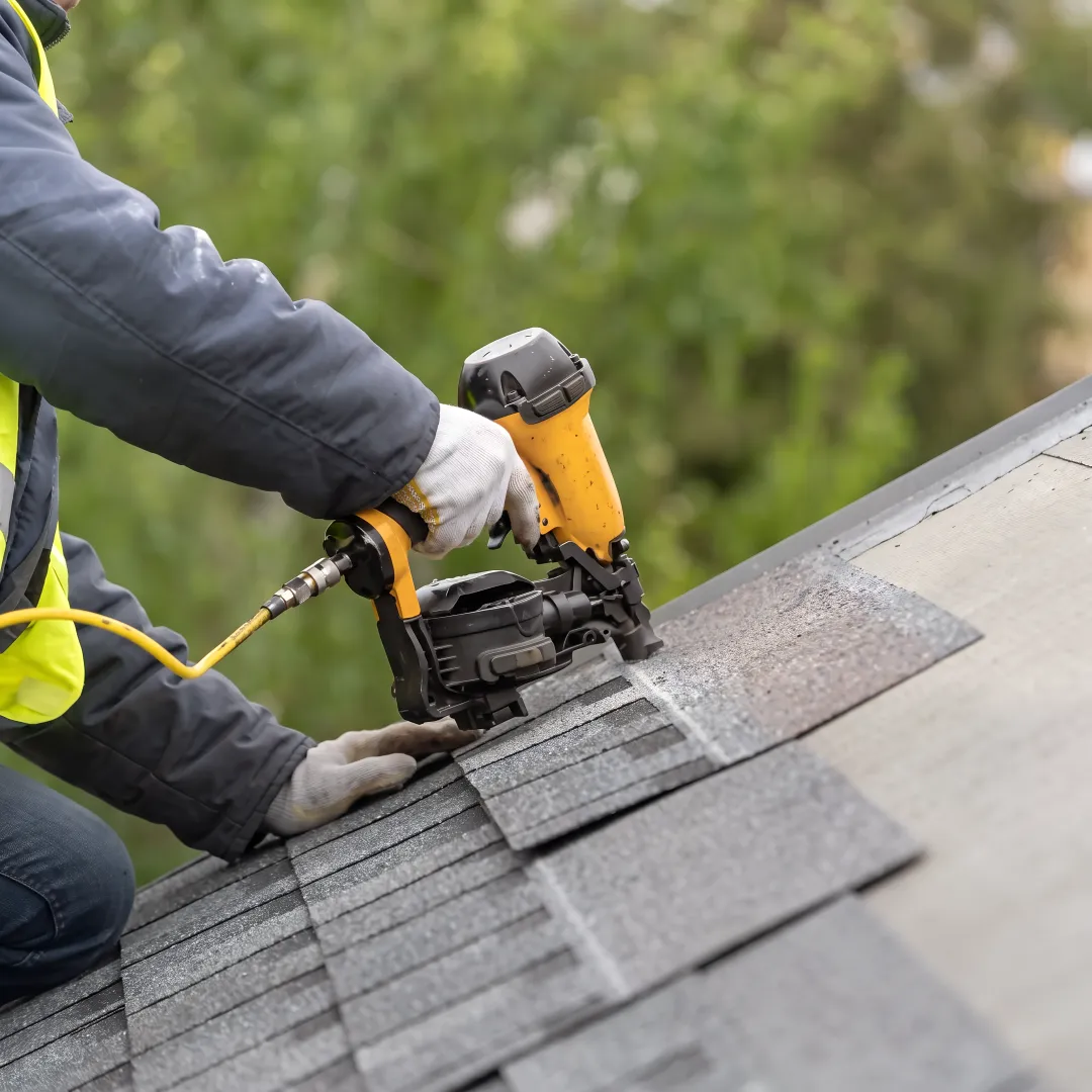 Installer fitting reflective shingles on a home