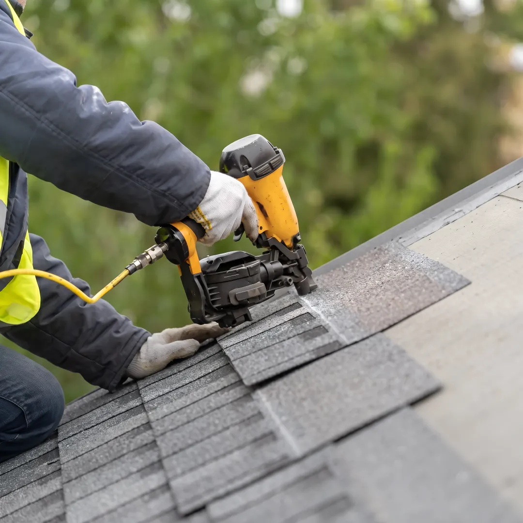 Roofer installing shingles on a home