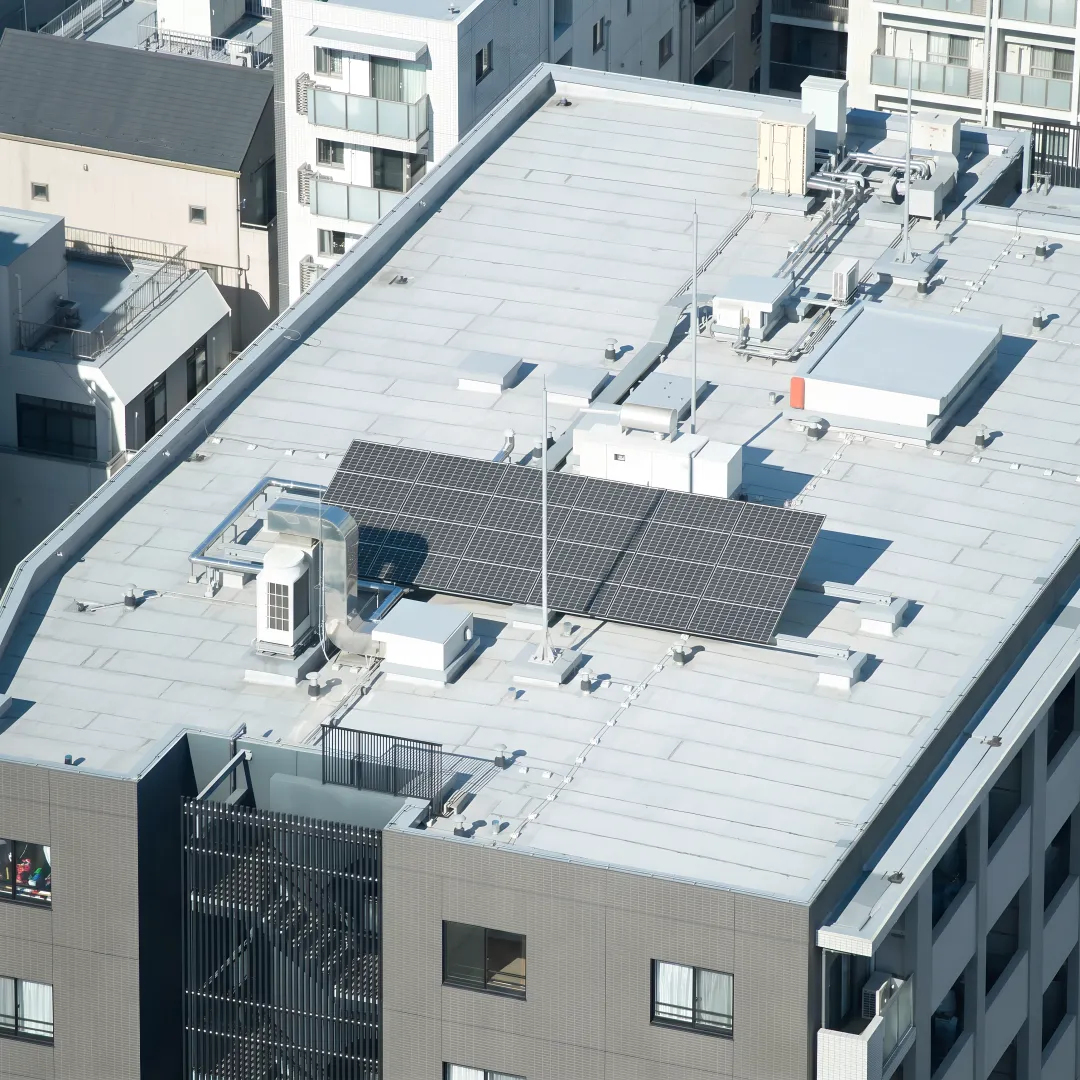 Roofing professional examining flat roof membrane