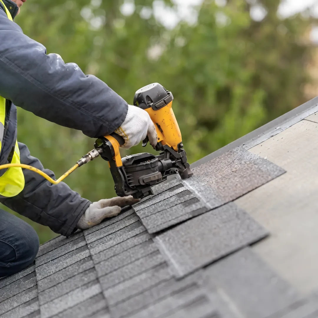 Technician repairing shingles on a home