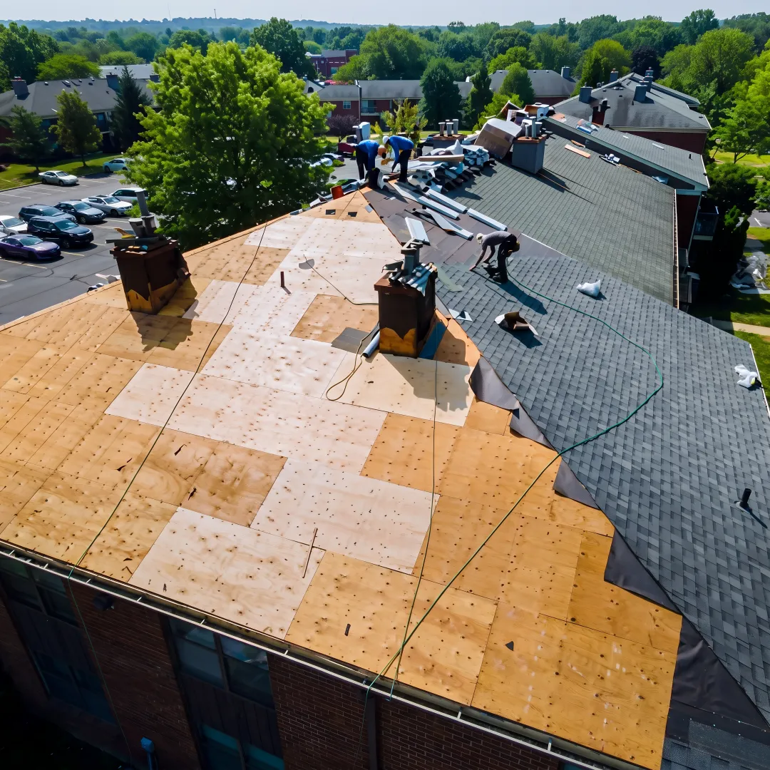 Roofer inspecting a cleared roof deck