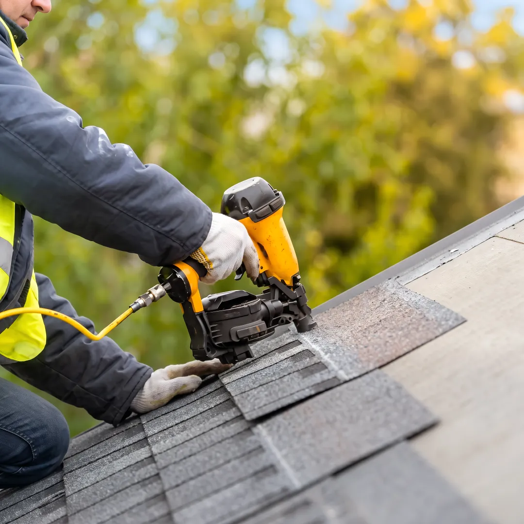 Installer securing shingles on a residential roof