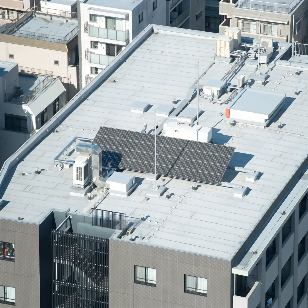 Professional inspecting a white coated flat roof