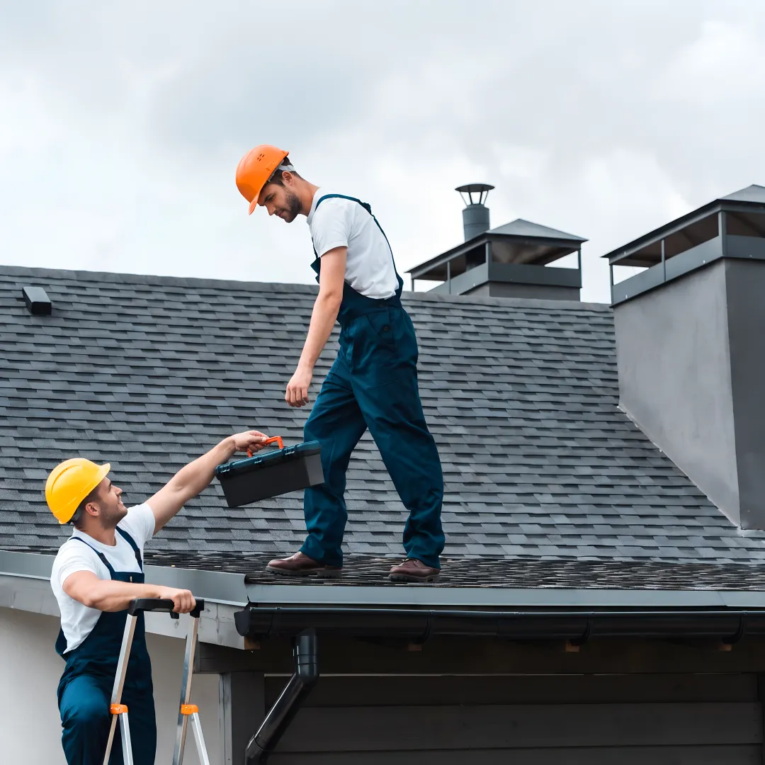 Roofing crew installing shingles on a home