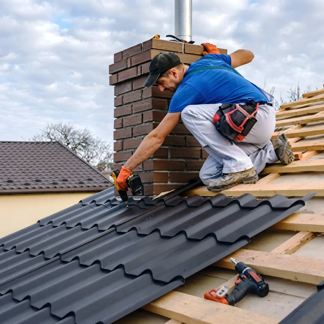 Roofer installing metal tile panels