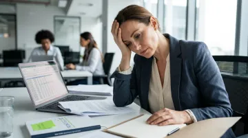 Exhausted manager experiencing burnout at desk surrounded by team in modern office