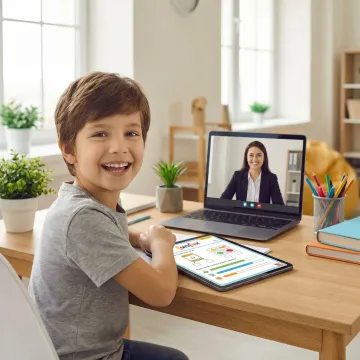 Child completing online OC test preparation worksheets with a tutor on screen