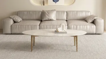 Oval marble coffee table with tapered legs in modern living room setting