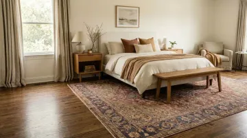 Vintage Persian rug anchoring neutral bedroom with layered textile palette