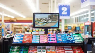 Retail in-store digital display screen at checkout counter promoting product offers