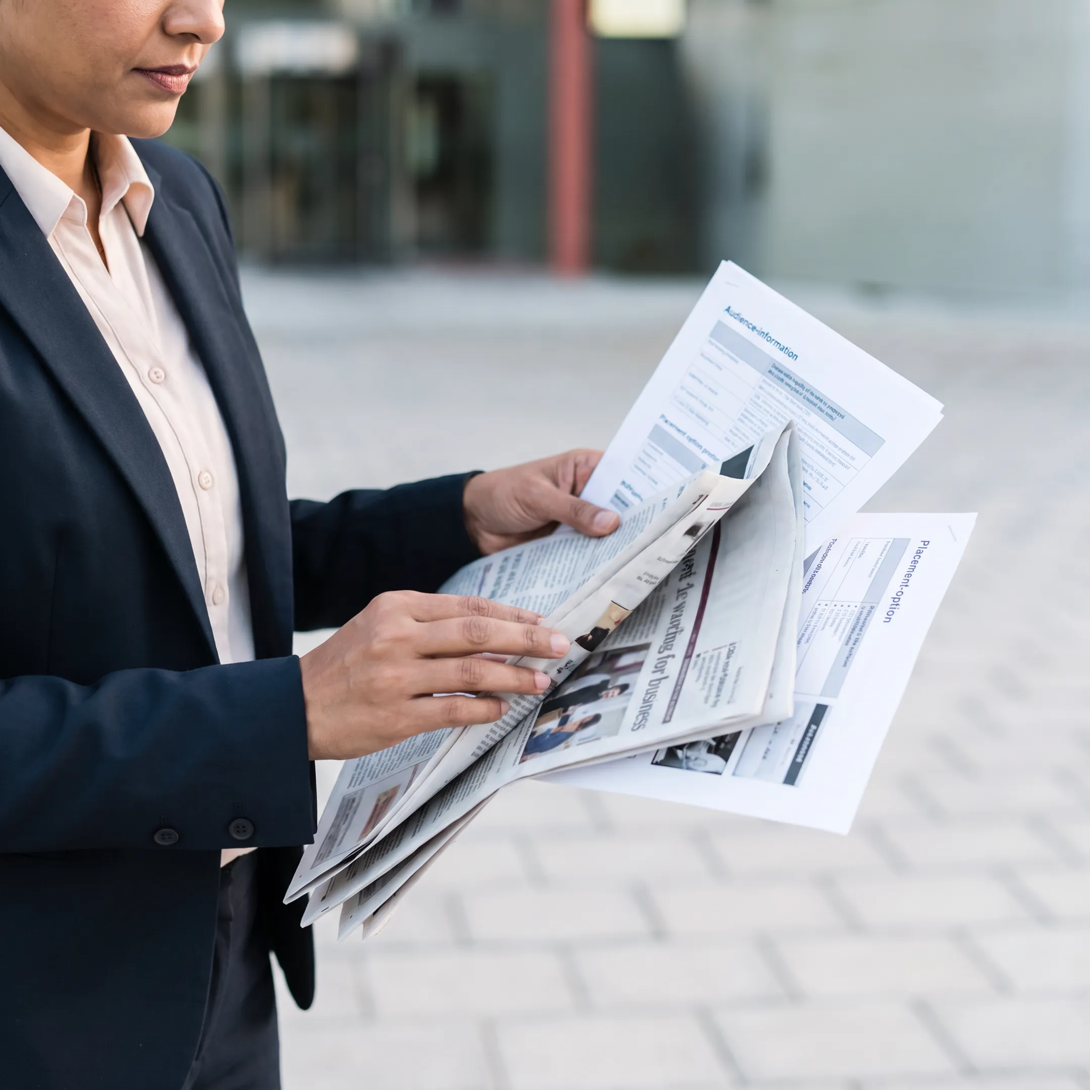 Media planner reviewing newspaper advertising placements and layouts