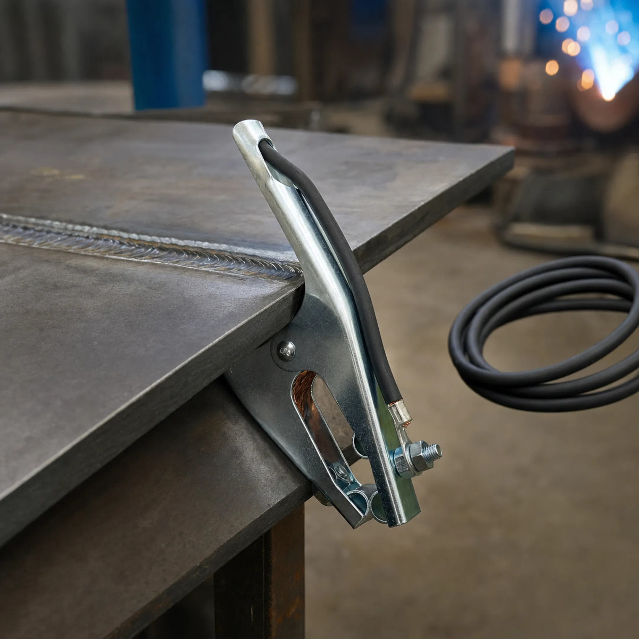 Properly installed welding ground clamp on clean bare metal surface