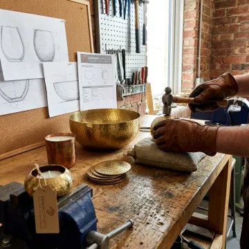 Handcrafted custom brass jewelry on artisan workbench