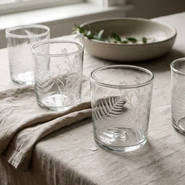 Custom etched glass tumblers arranged on a tabletop