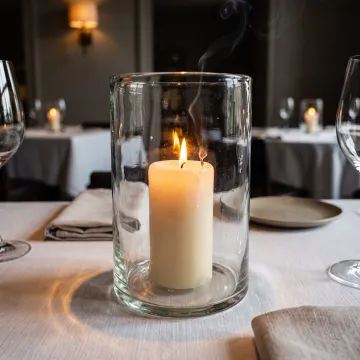 Restaurant table with glass candle hurricane vessel