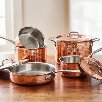 Handcrafted copper cookware arranged in a modern kitchen