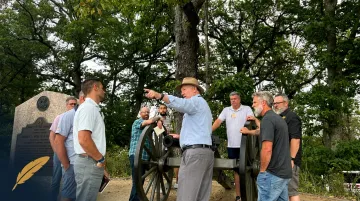 Executives walking historic Gettysburg battlefield during leadership decision-point simulation