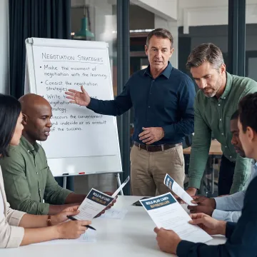 Facilitator guiding leaders through a negotiation exercise