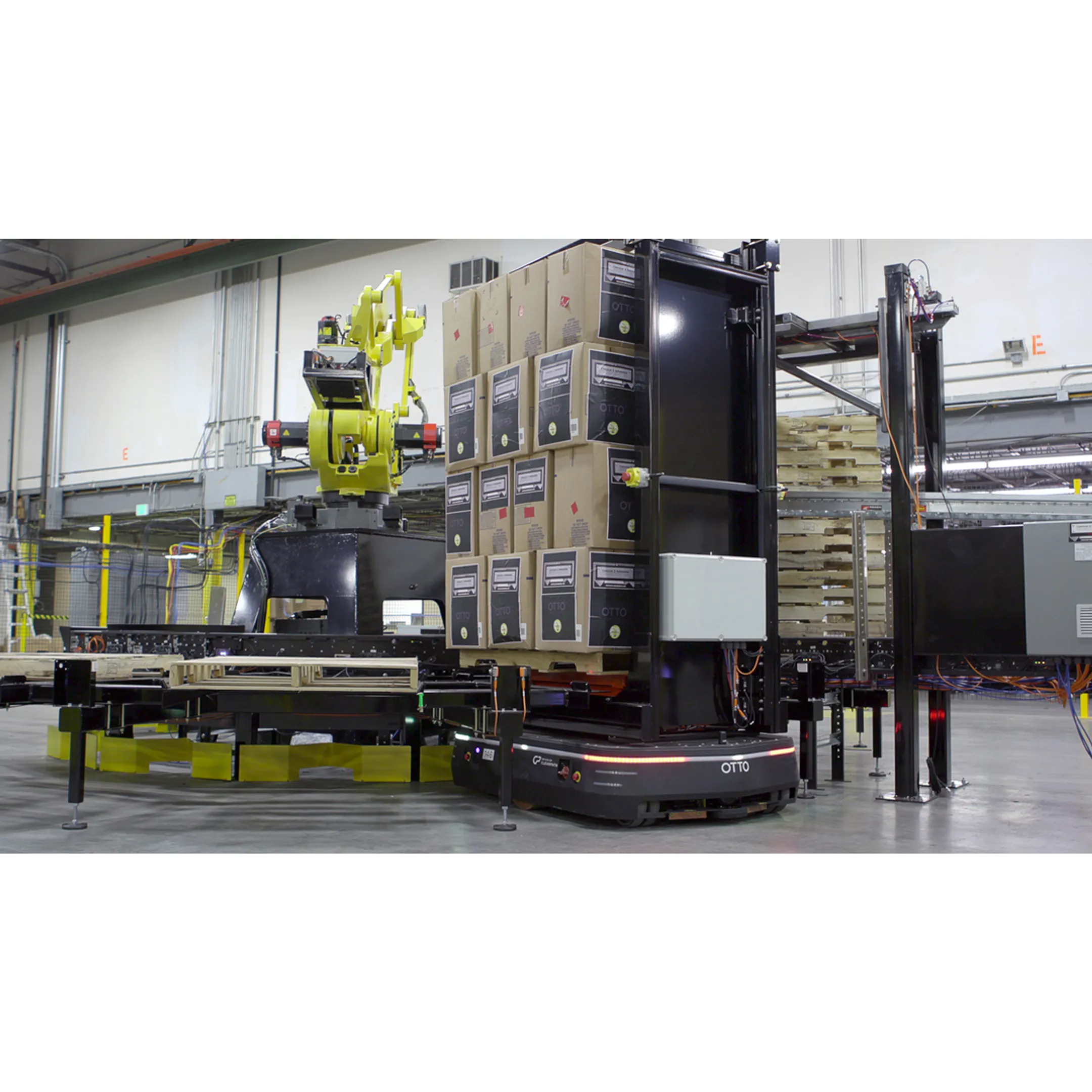 Engineer reviewing mobile robot workflow in a factory