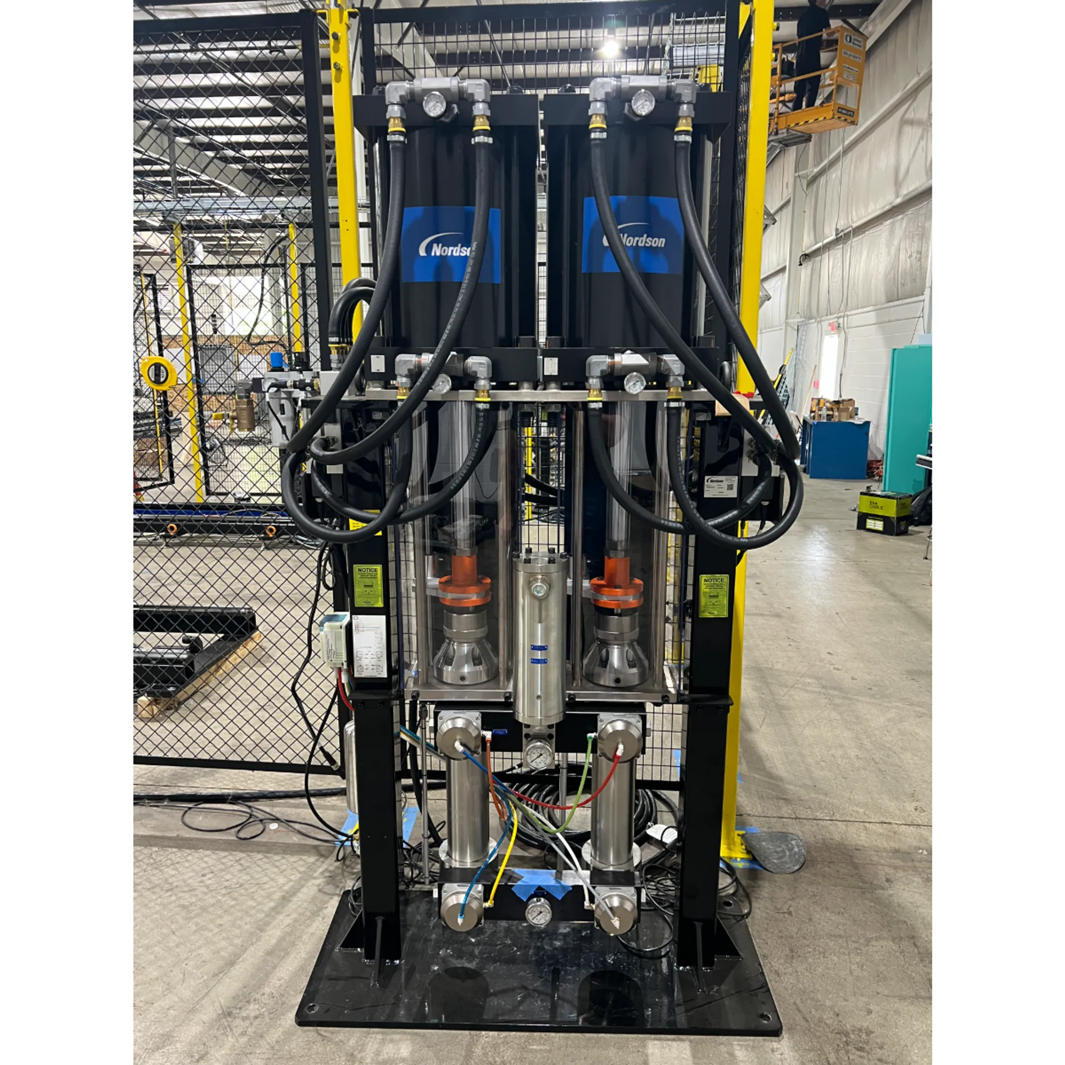 Robotic arm applying adhesive along a manufactured components