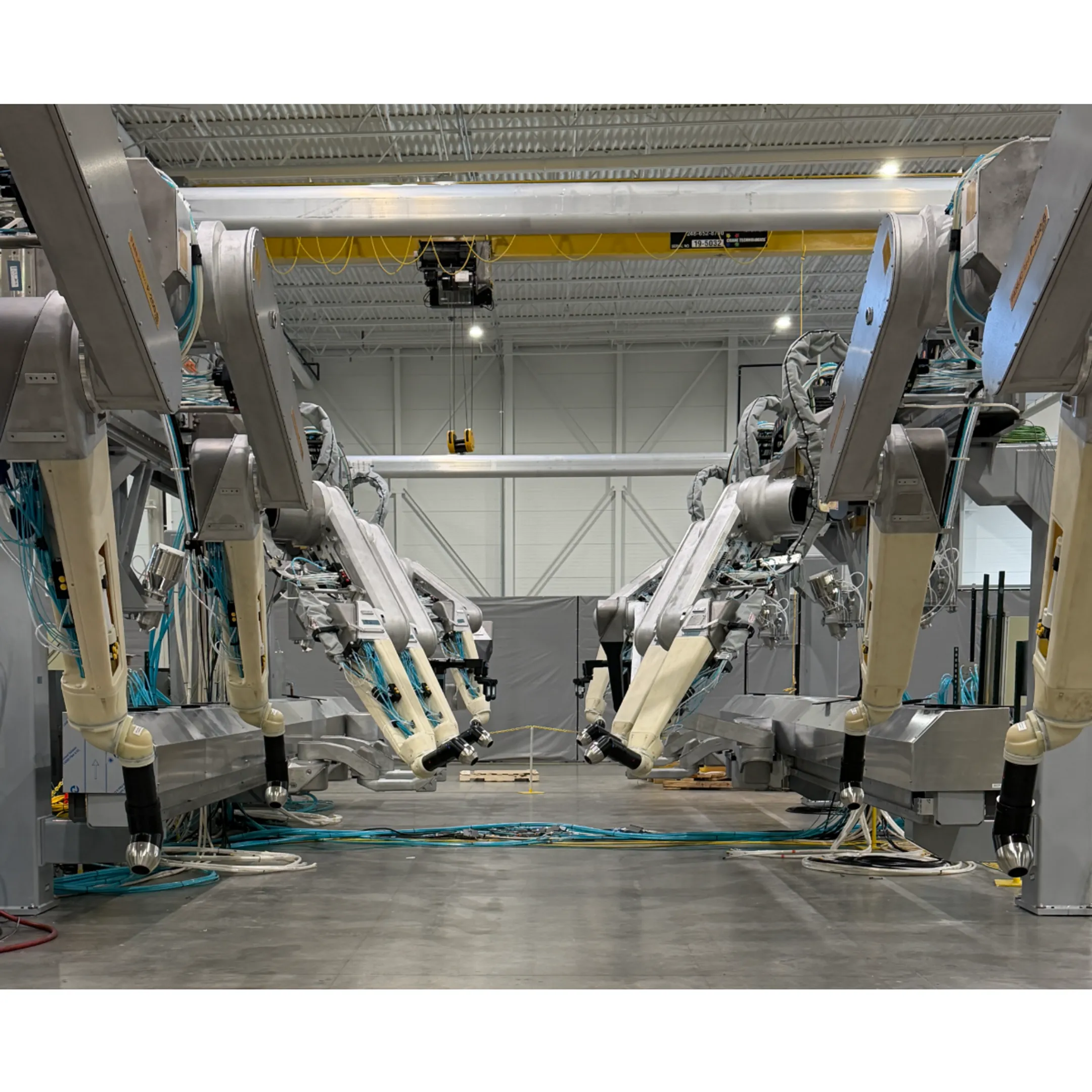 Engineer reviewing a robotic coating system beside automated paint equipment