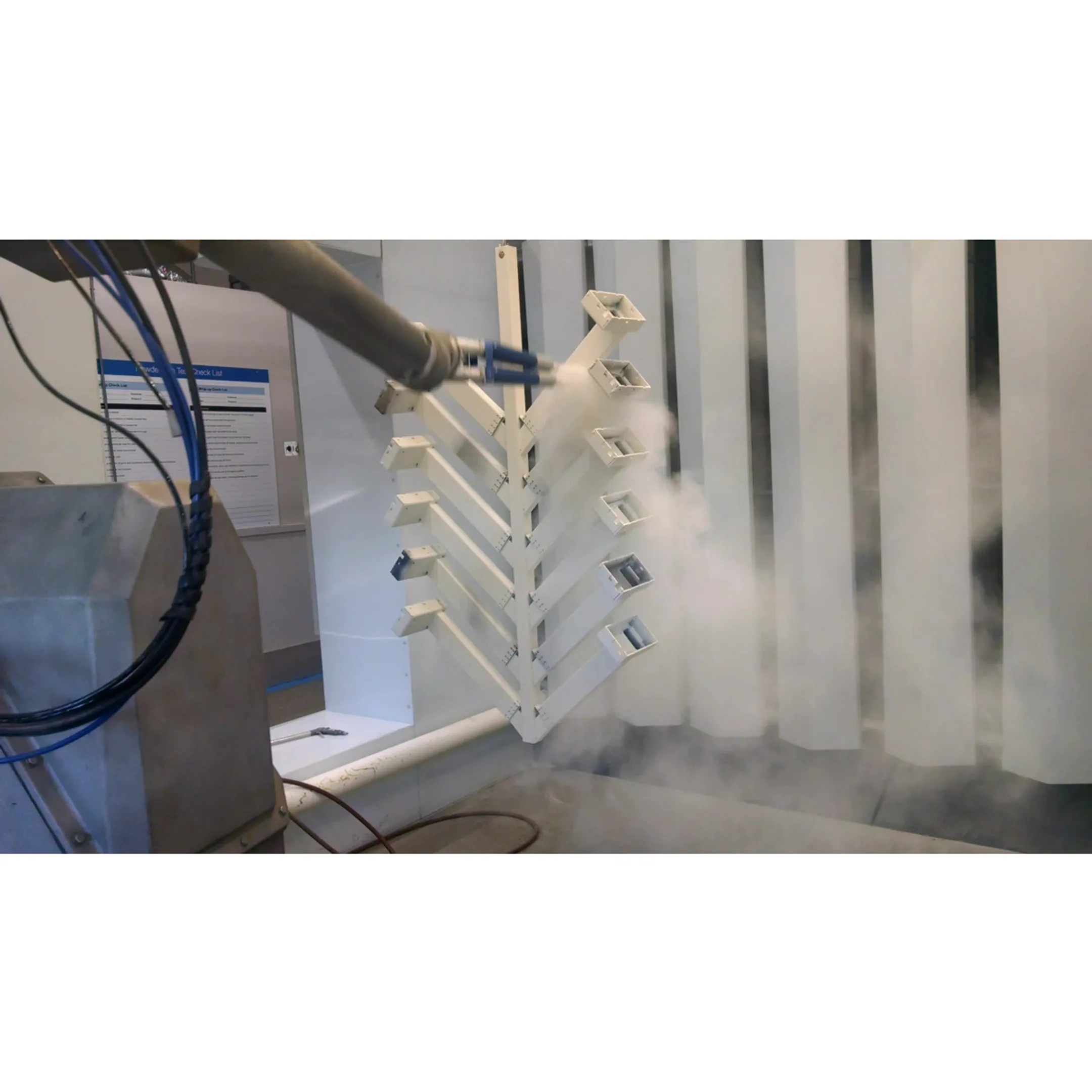 Engineer reviewing robotic powder coating cell for agricultural equipment