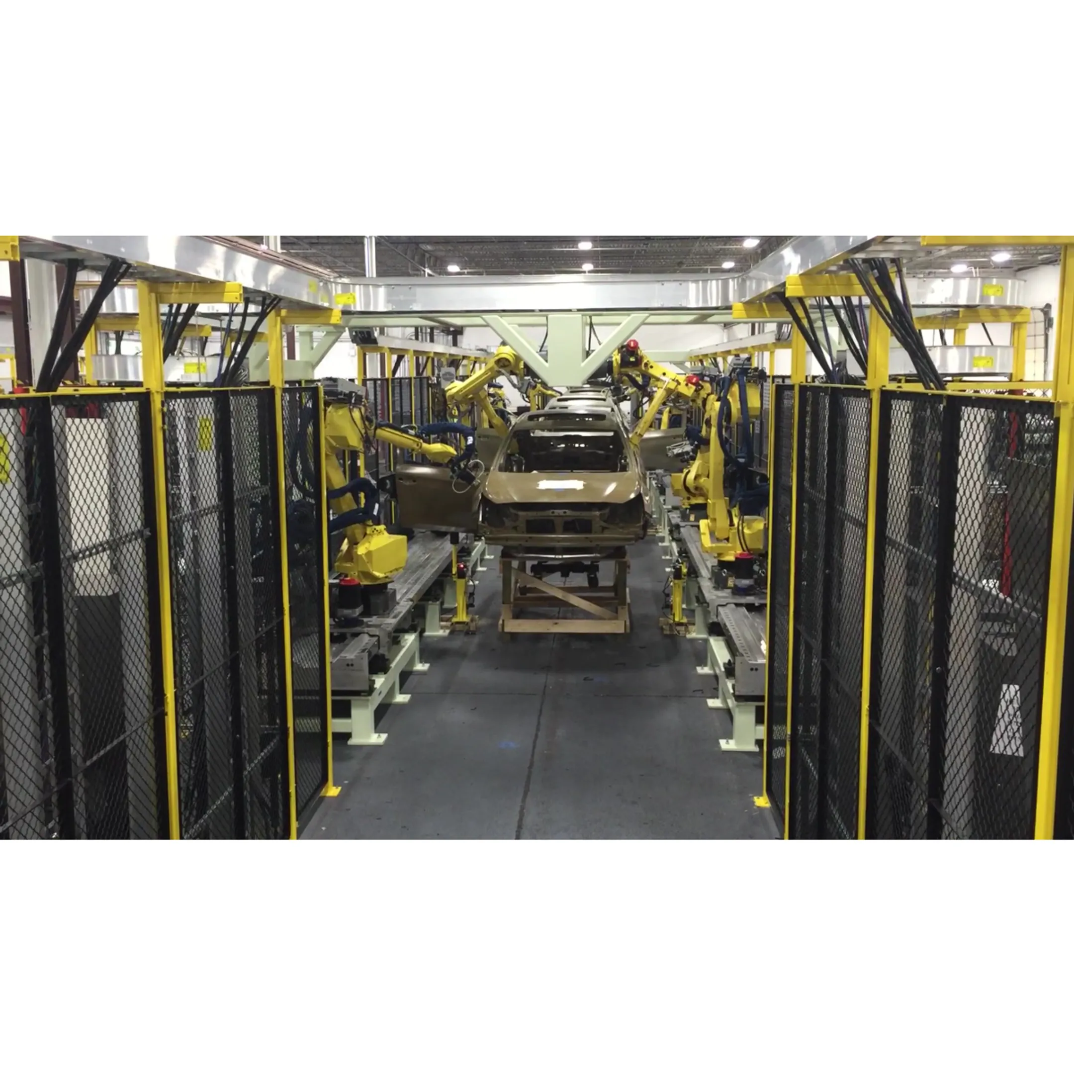 FANUC robot applying adhesive along a vehicle body panel seam