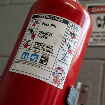 Vinyl fire extinguisher instruction label on red extinguisher